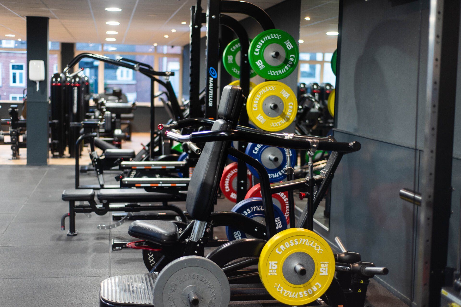 Interieur van de sportschool met gewichtsmachines en schijven.