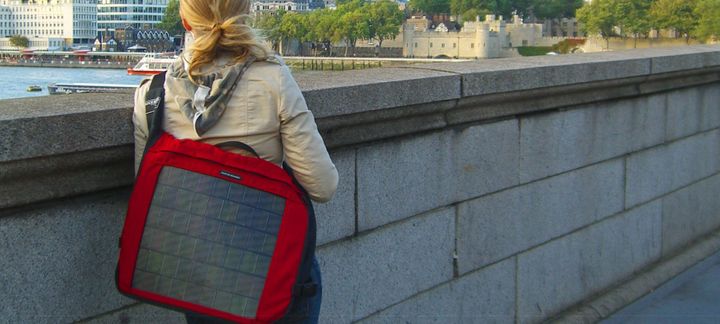 a woman looking over a river with a solar backpack on