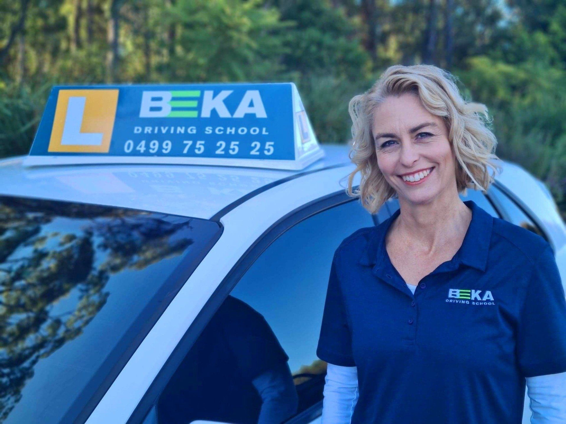 Bec standing near her car
