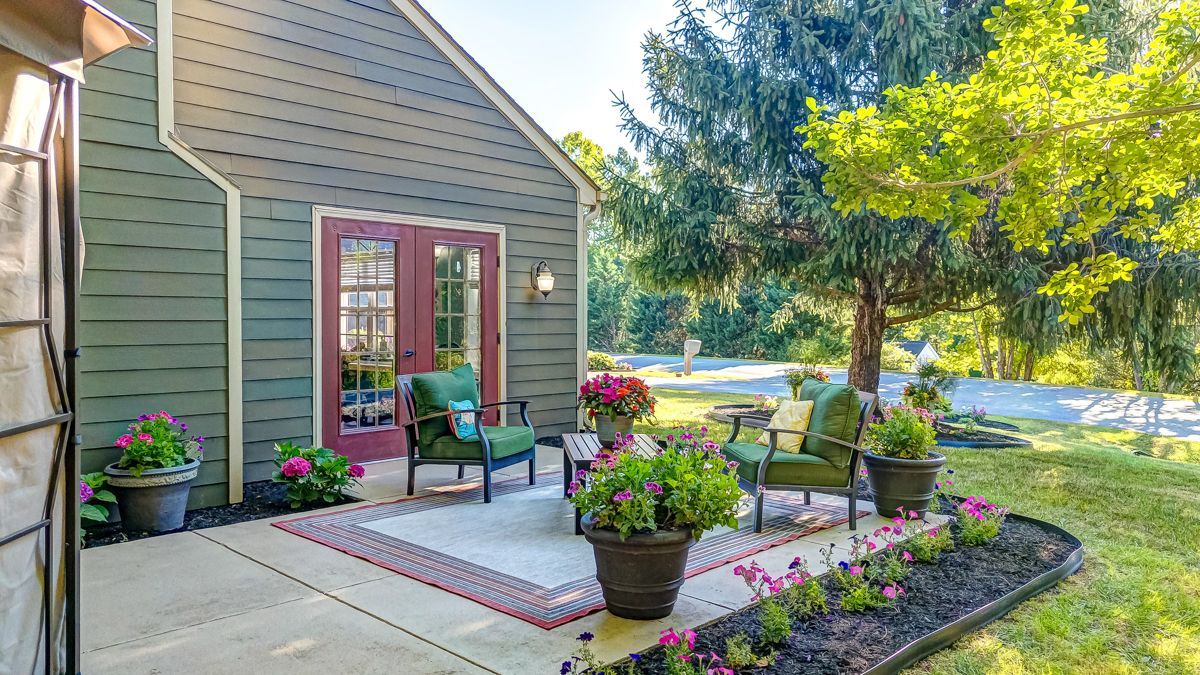 A house with a patio and chairs in front of it.