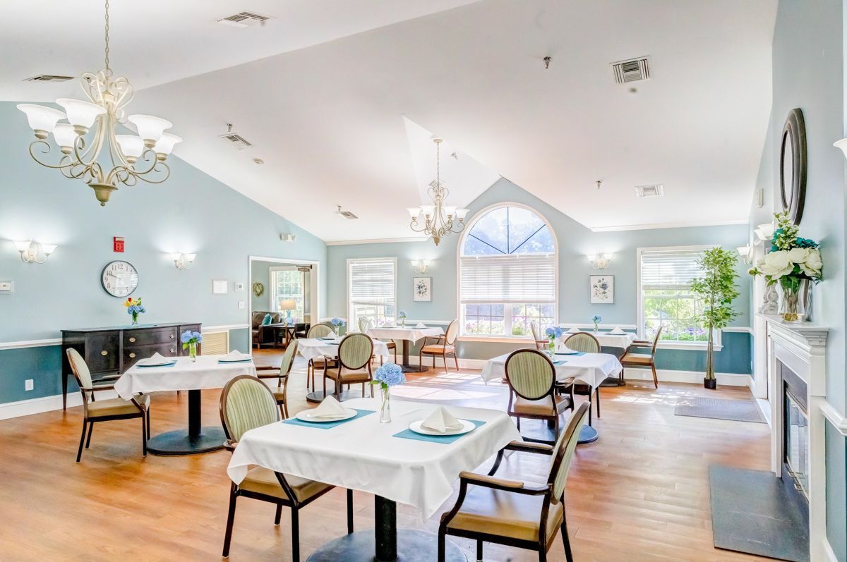 A large dining room with tables and chairs and a fireplace.