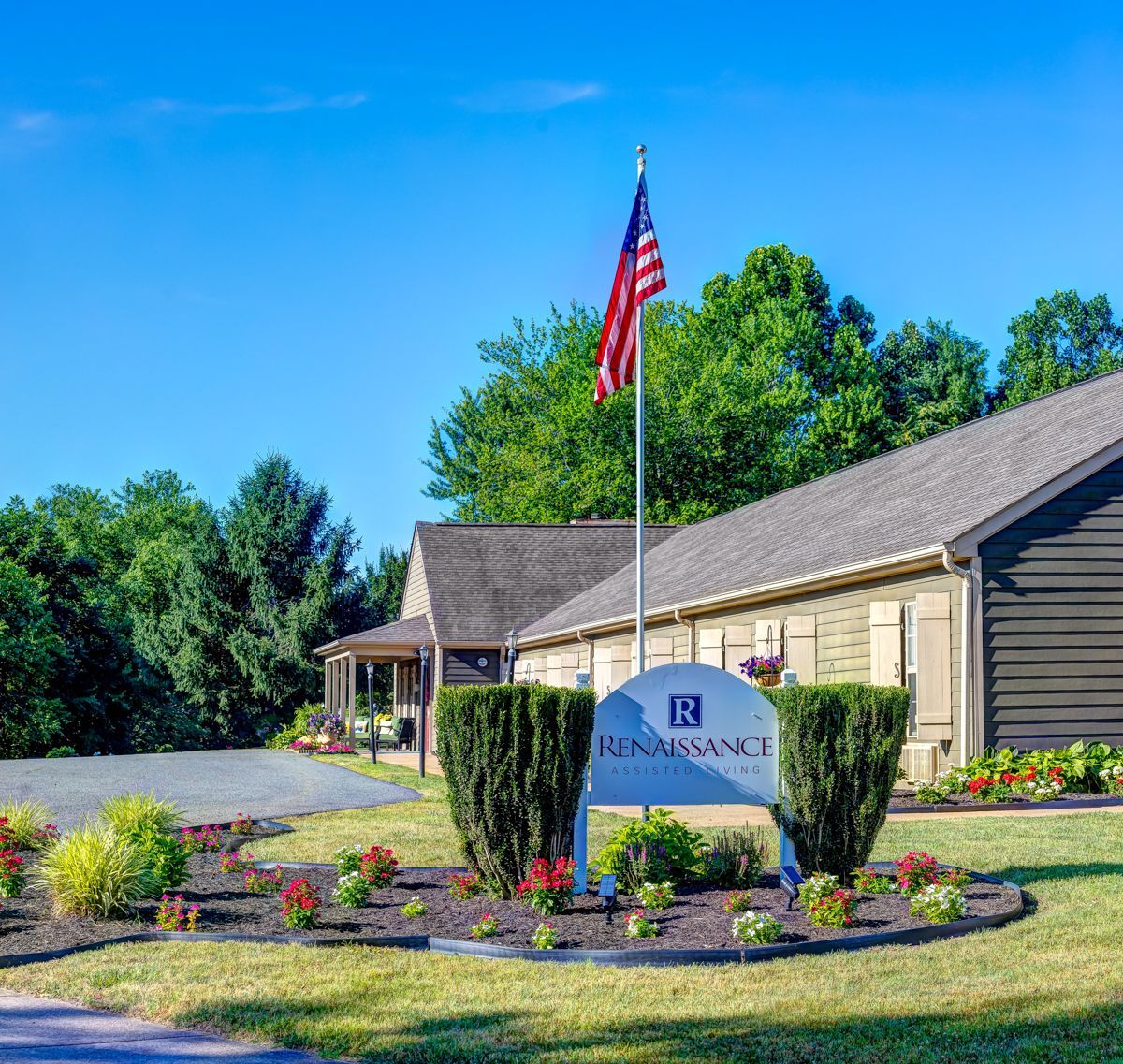 A house with a sign in front of it and a flag on a pole.
