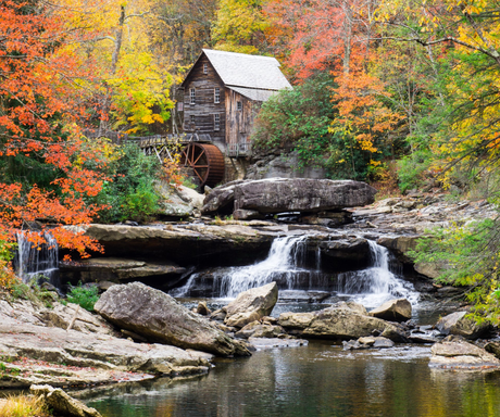 There is a waterfall and a water mill in the background.