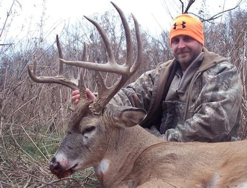 Man posing with deer antlers