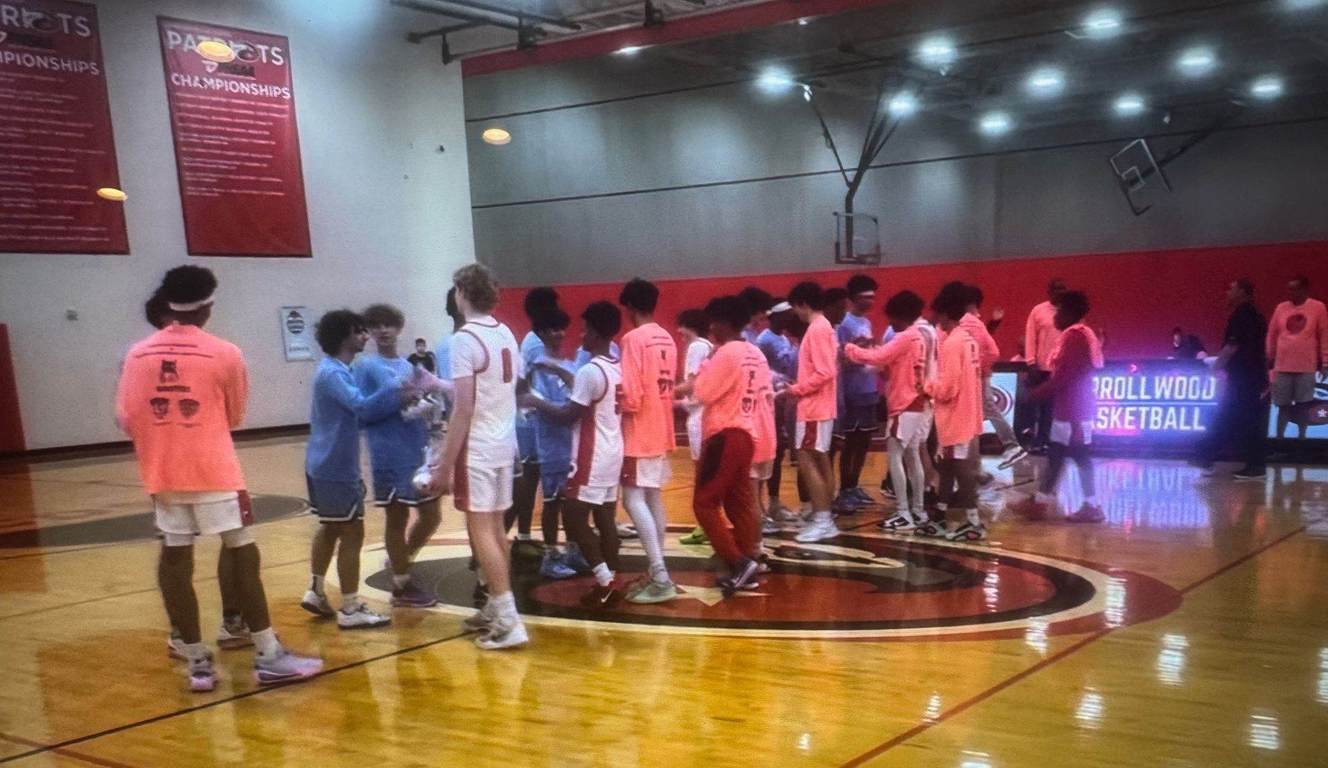 Basketball game in progress; teenage boys in blue and white uniforms; action in a gymnasium.