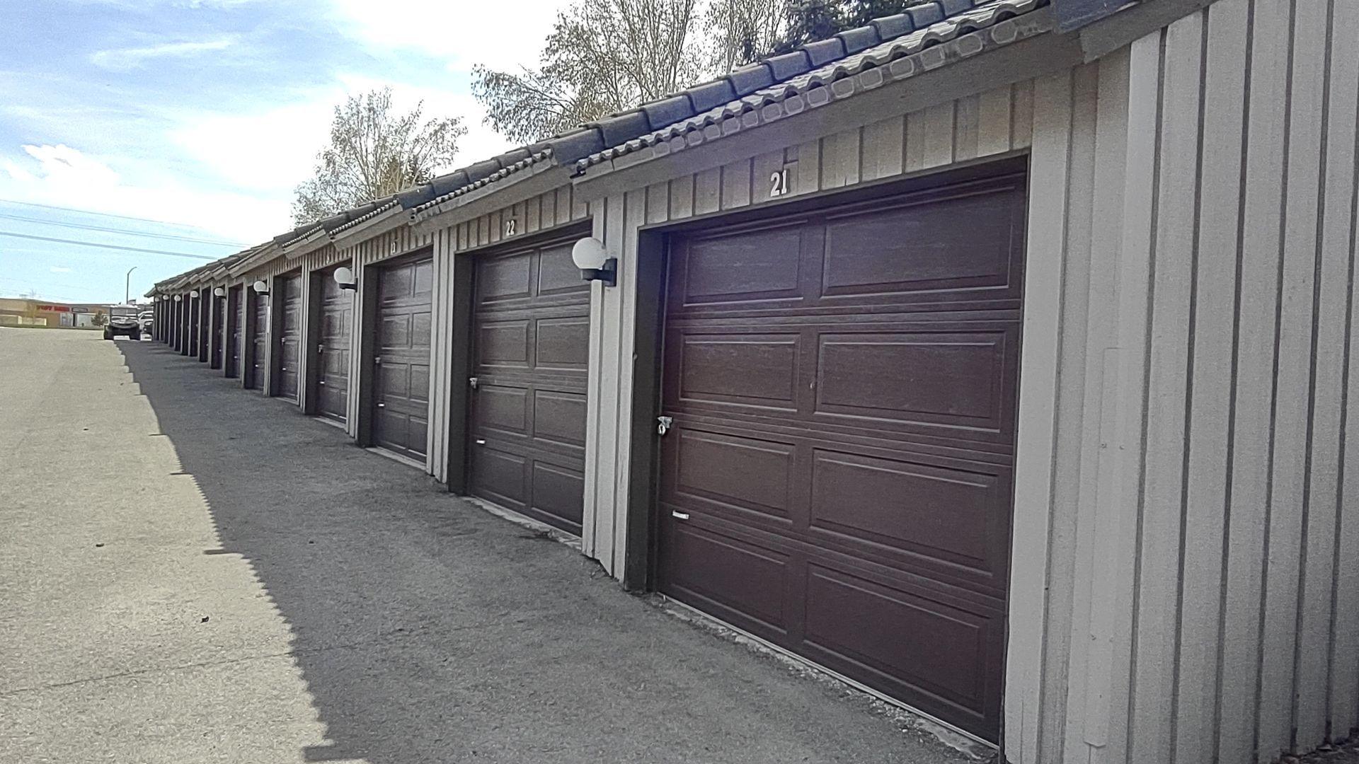A row of brown garage doors are lined up next to each other.