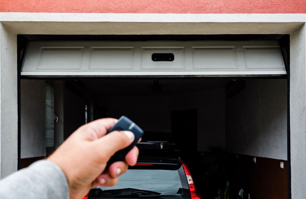 A Person Holds a Remote to Operate a Garage Door — Above and Beyond Locksmiths in Hope Island, QLD