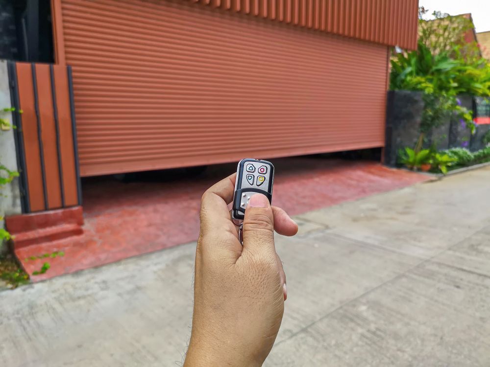 A Hand Holding a Remote Control — Above and Beyond Locksmiths in Pimpama, QLD