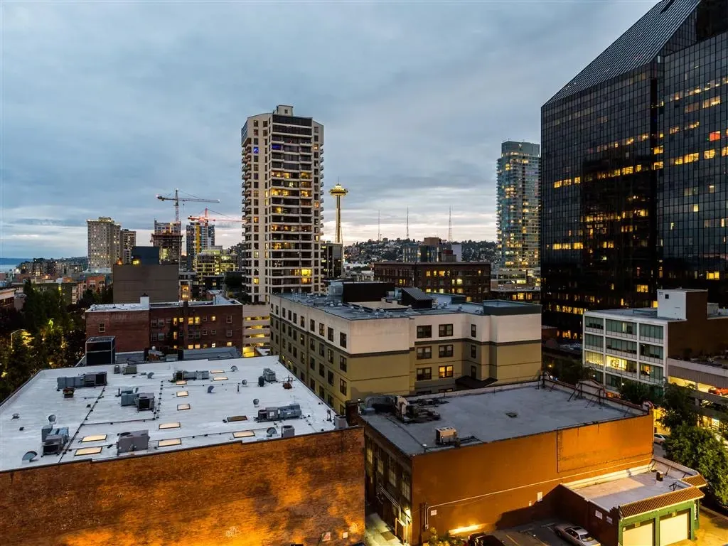 Cityscape view of apartment buildings at dusk with city lights.