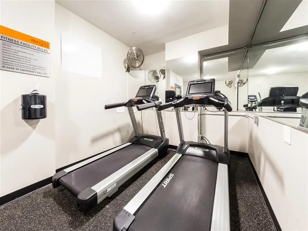 Fitness center with two treadmills and mirrors.