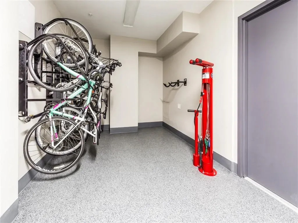 Bicycle storage area with vertical racks and a bike repair station.