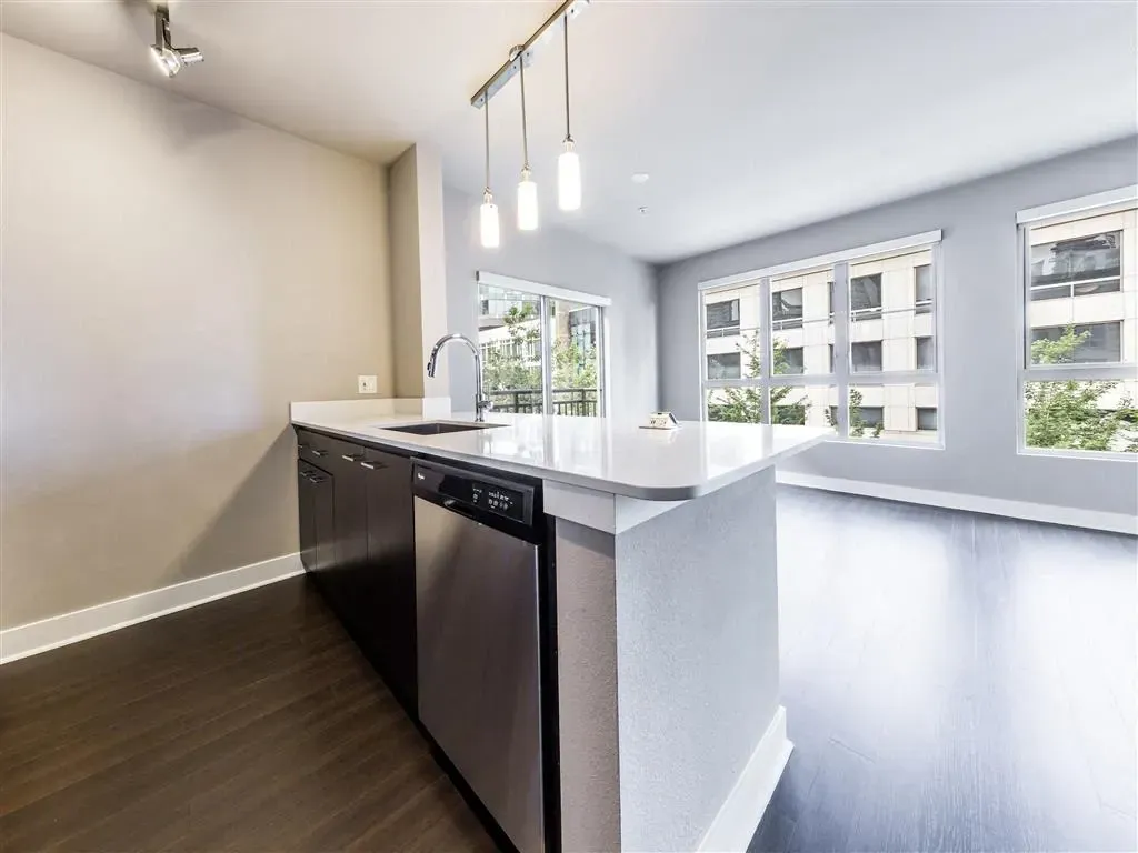 Modern kitchen with island, stainless steel appliances, and natural light.