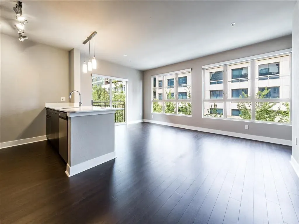 Spacious living area with a modern kitchen island and large windows overlooking a courtyard.