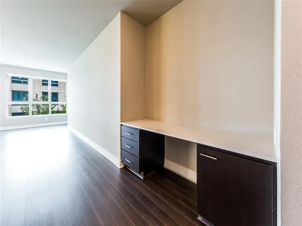 Built-in desk area with cabinets and drawers in a modern apartment.