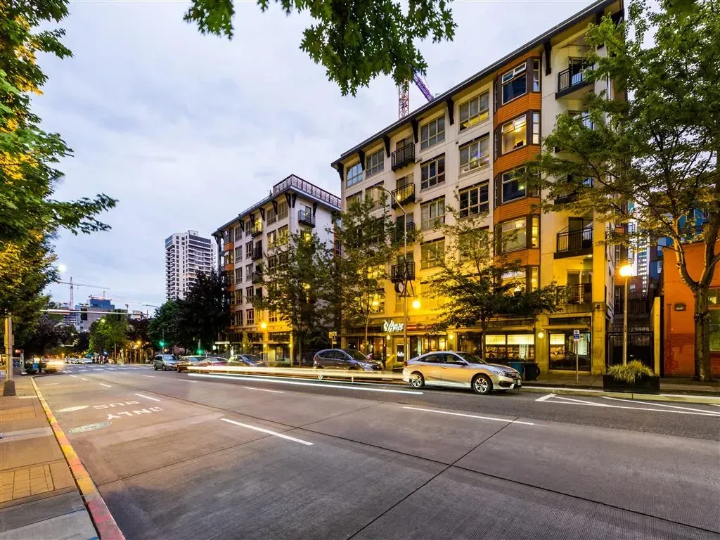 Modern apartment building exterior on a tree-lined street at dusk
