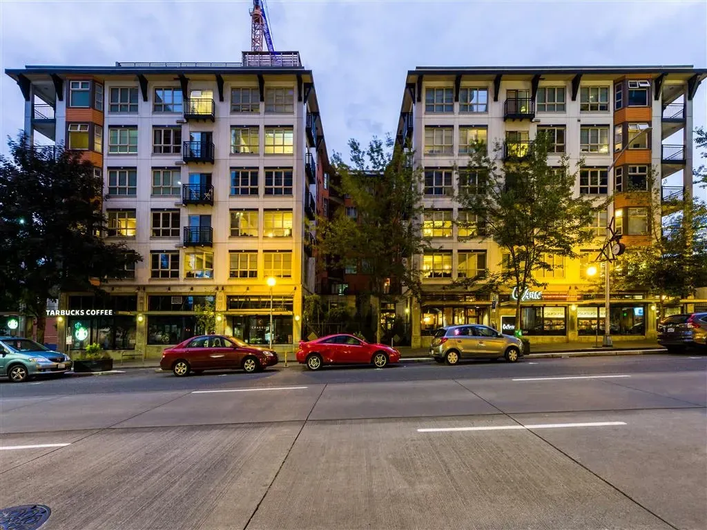 Exterior view of modern apartment buildings with Starbucks and other businesses on the ground floor.