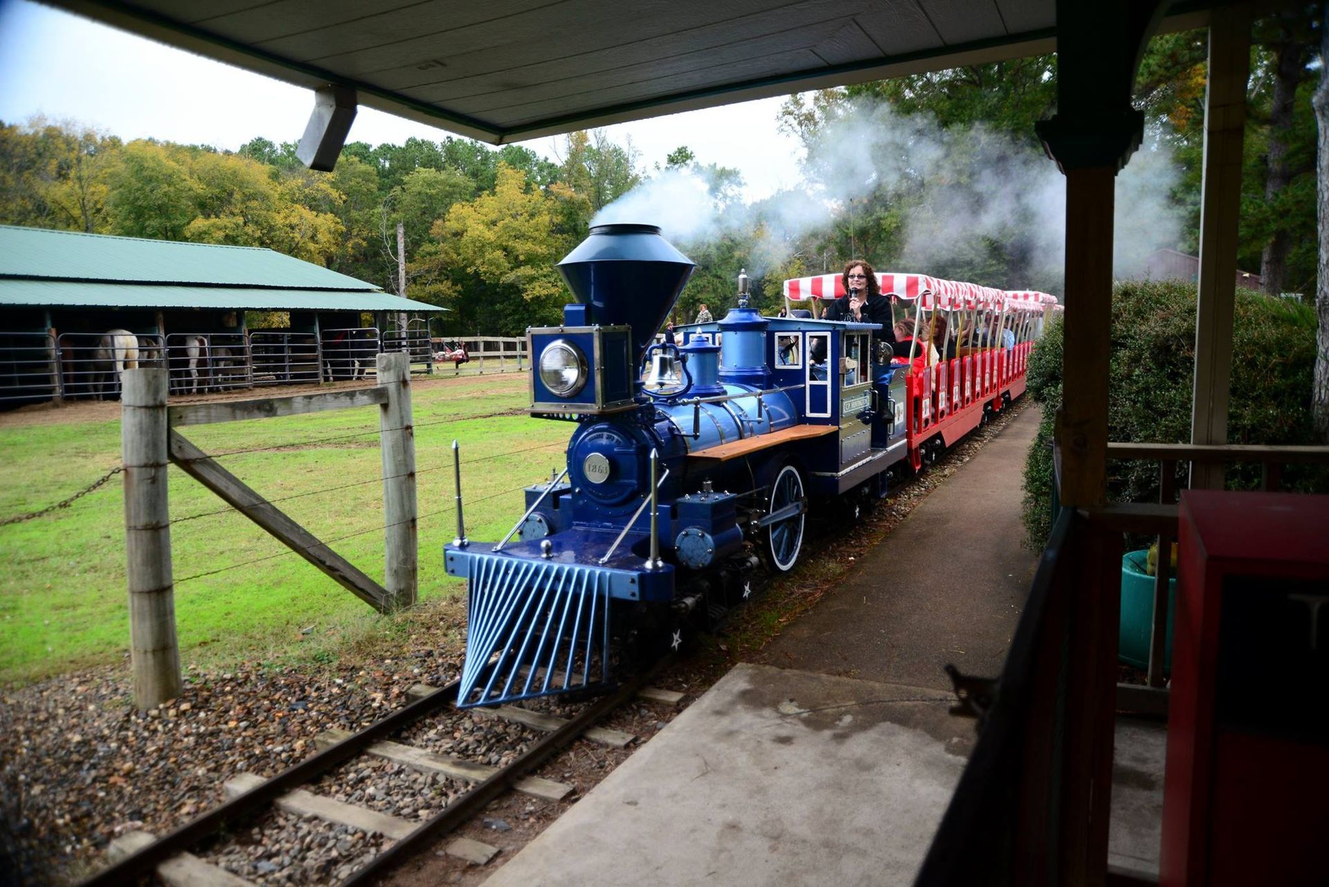 A blue and red train is pulling into a station