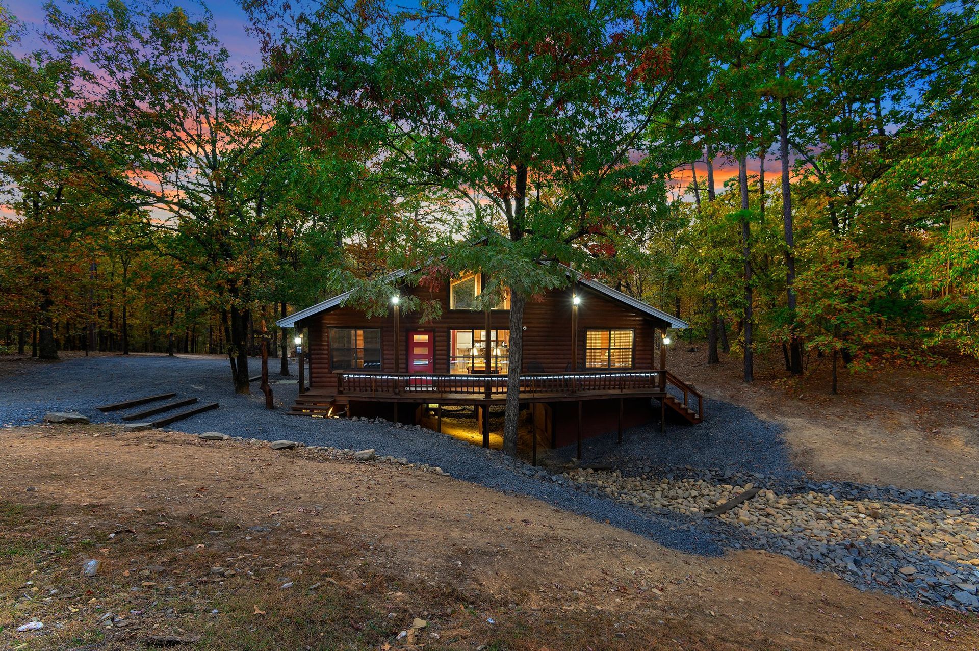 A log cabin in the middle of a forest at night.