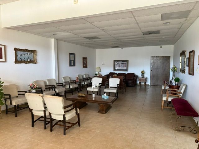 Spacious waiting room with beige tile floor, rows of chairs, and framed wall art