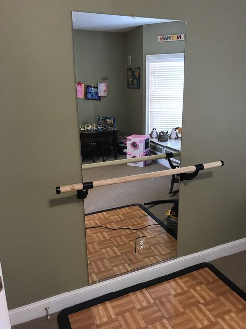 Exercise bar mounted across a doorway opening in a home interior.