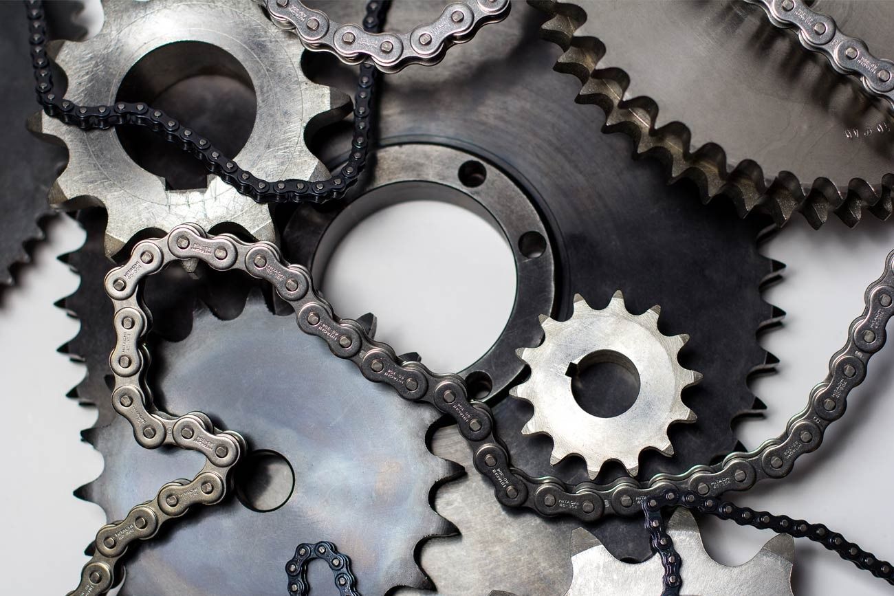 Gears and chains, arranged together. Metal machinery.