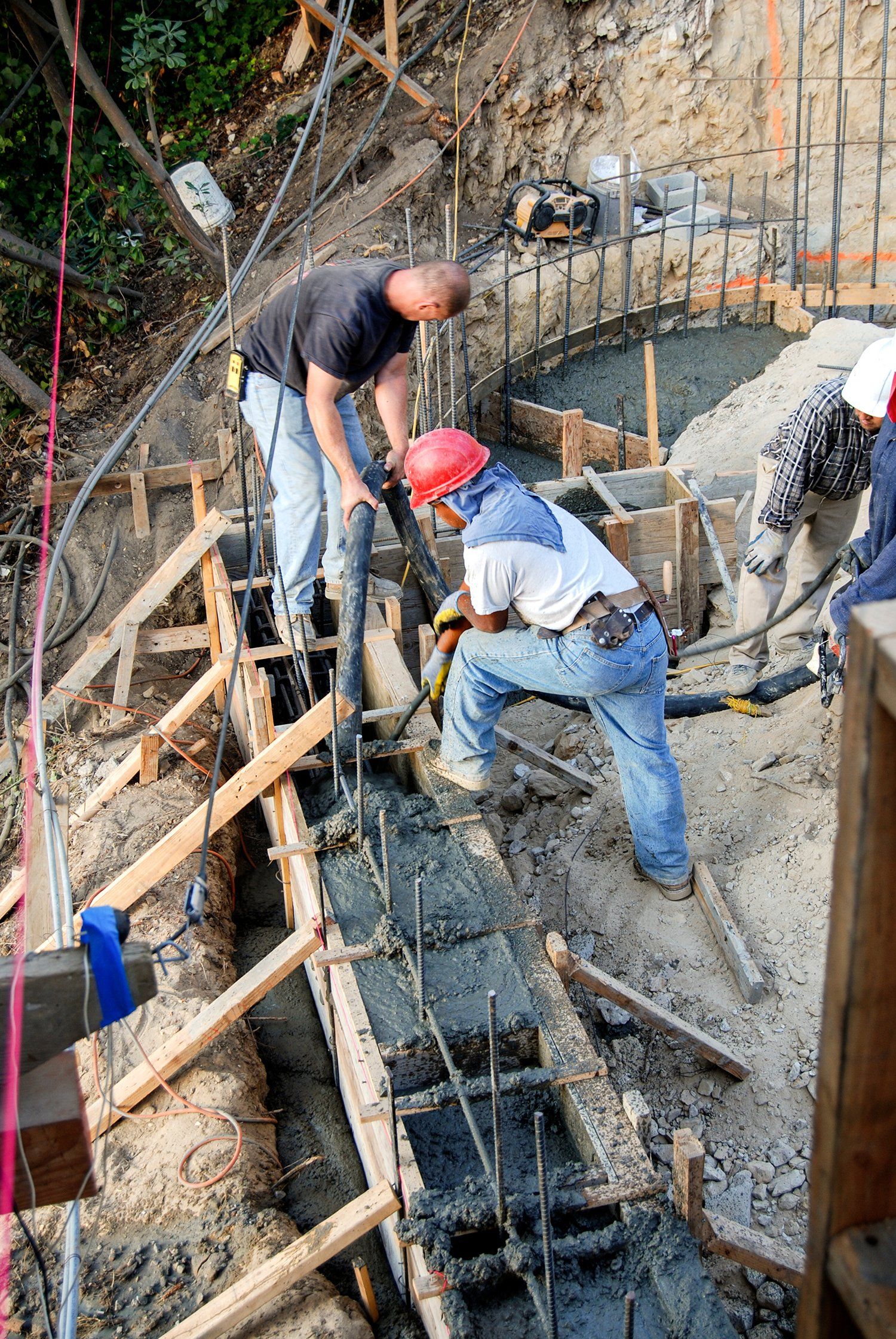 A group of construction workers are working on a concrete wall.