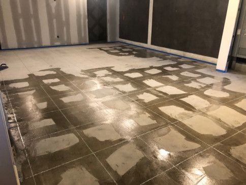 A concrete floor is being painted in a room.