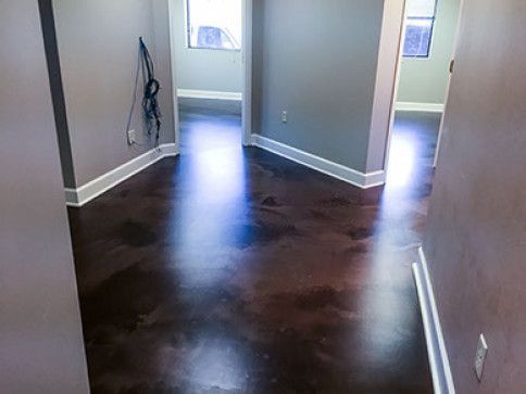 A hallway with a hardwood floor and a window