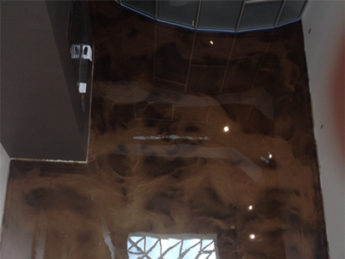 A shiny brown floor in a room with a ceiling.