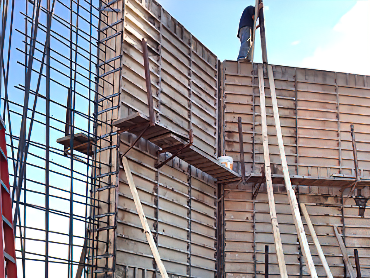 A man is standing on a scaffolding on top of a building under construction