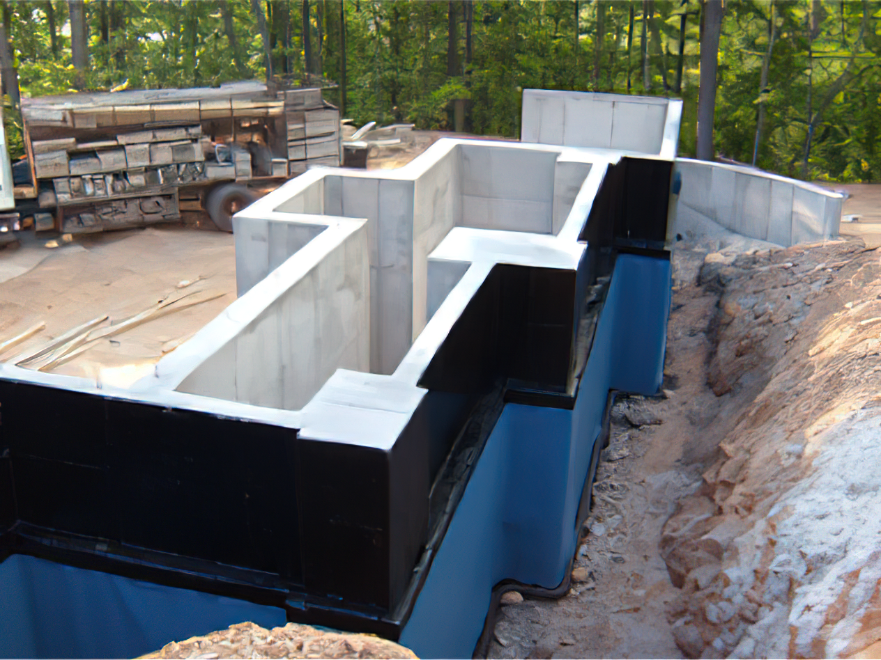 A large concrete structure is being built on top of a dirt hill