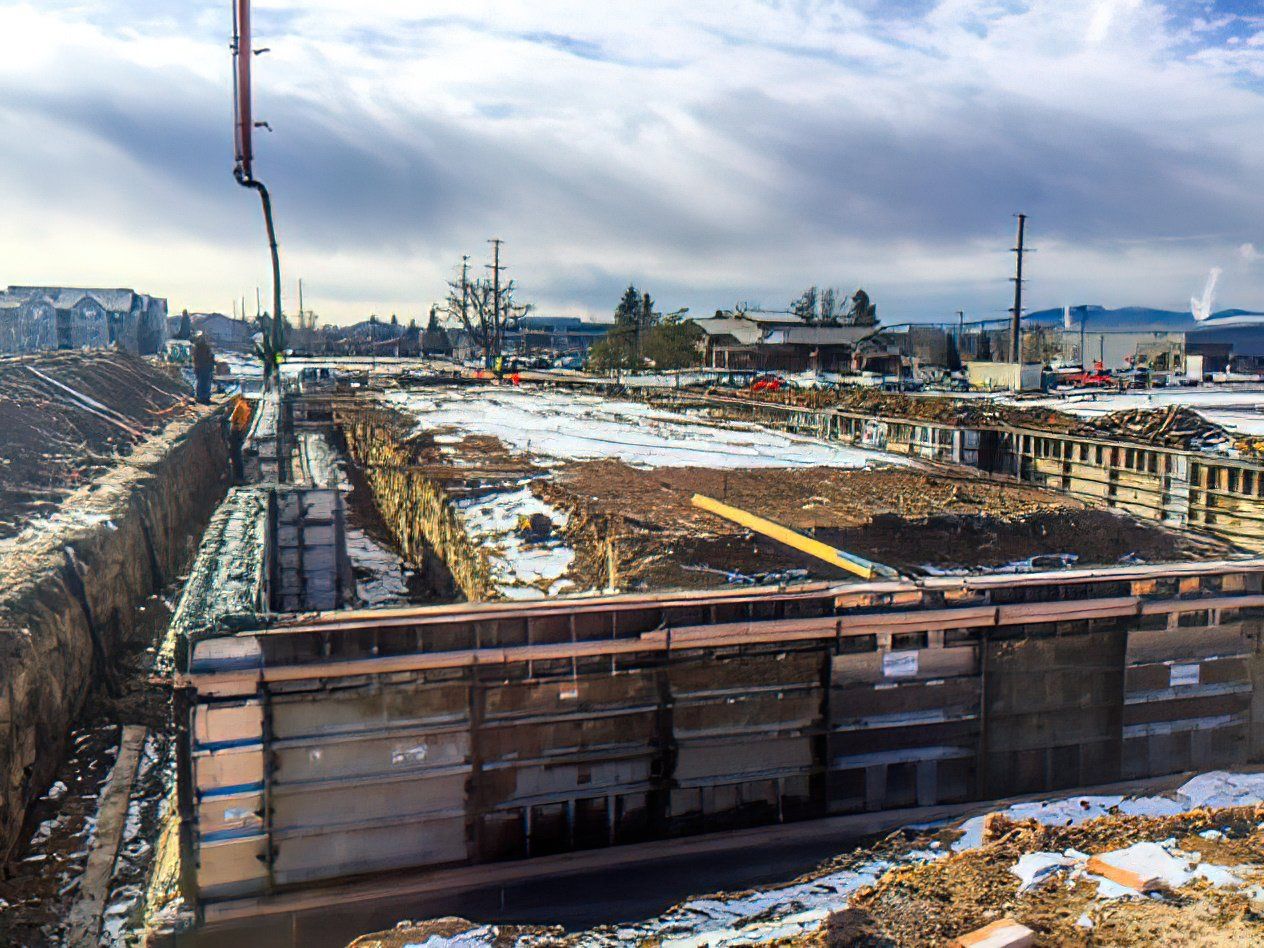 A construction site with a lot of dirt and snow on the ground.