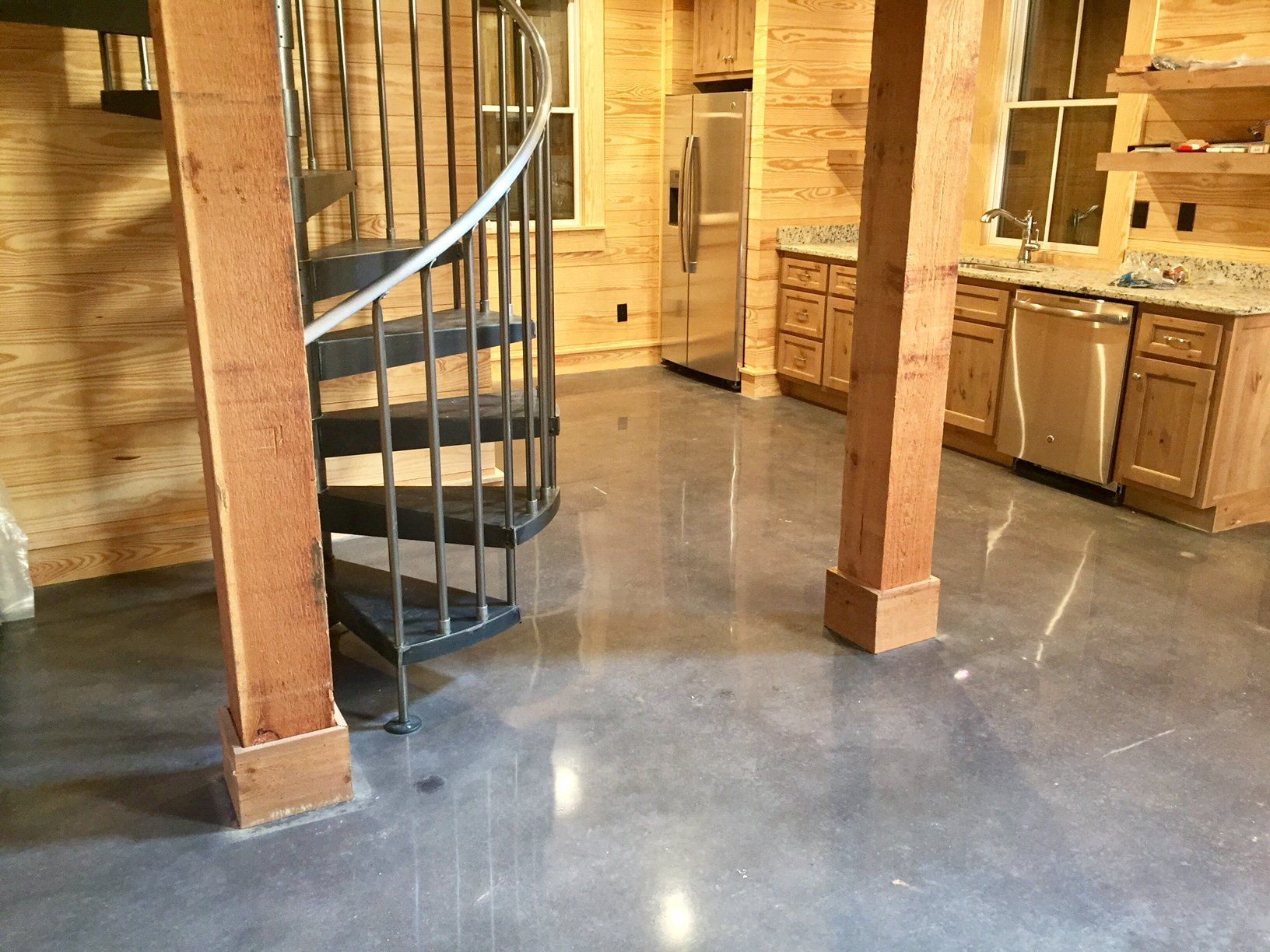 A kitchen with a spiral staircase and stainless steel appliances.