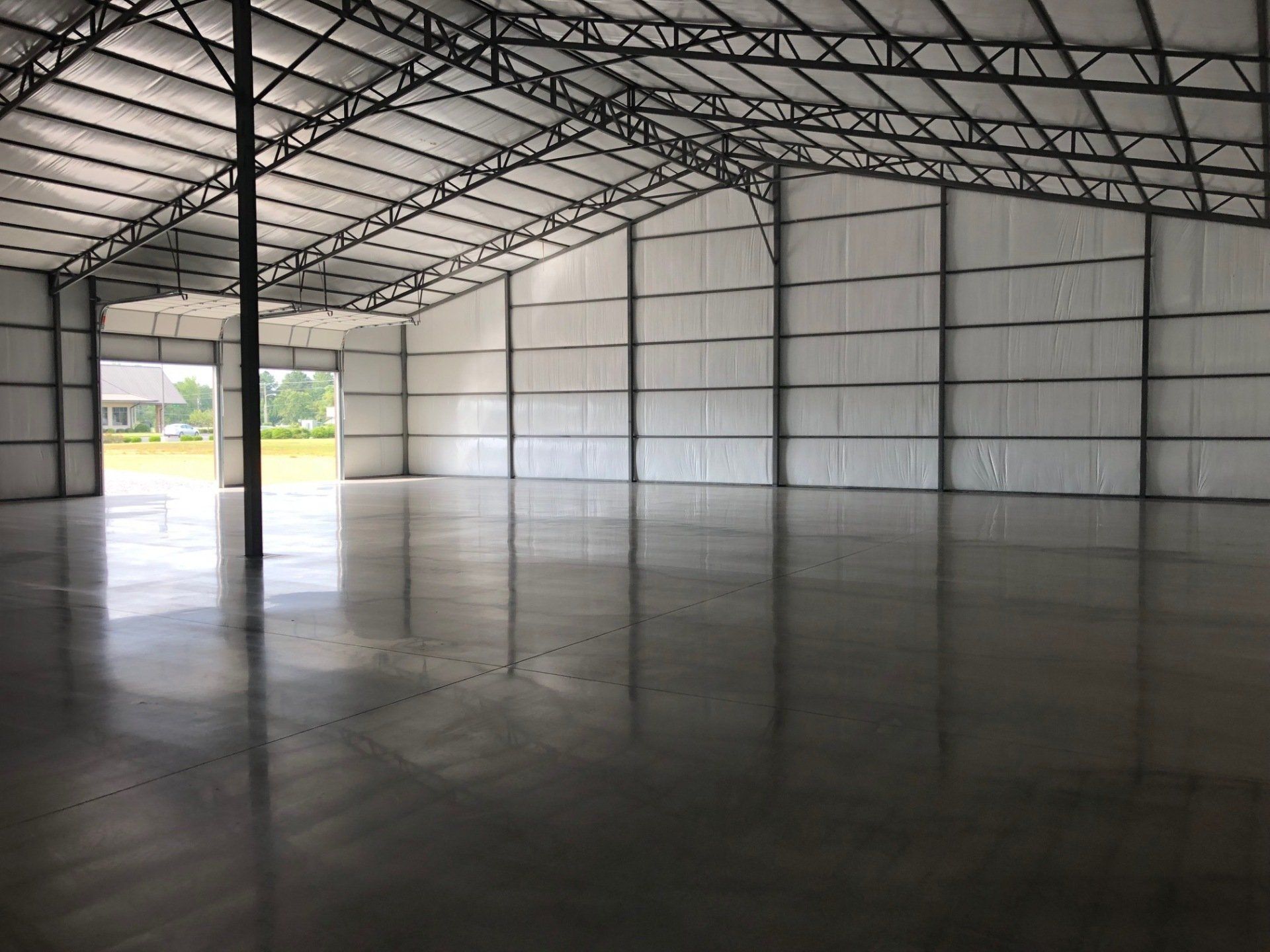 A large empty warehouse with a concrete floor and a metal roof.
