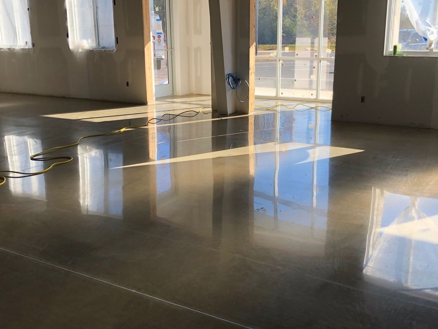 A large room with a shiny concrete floor and a lot of windows