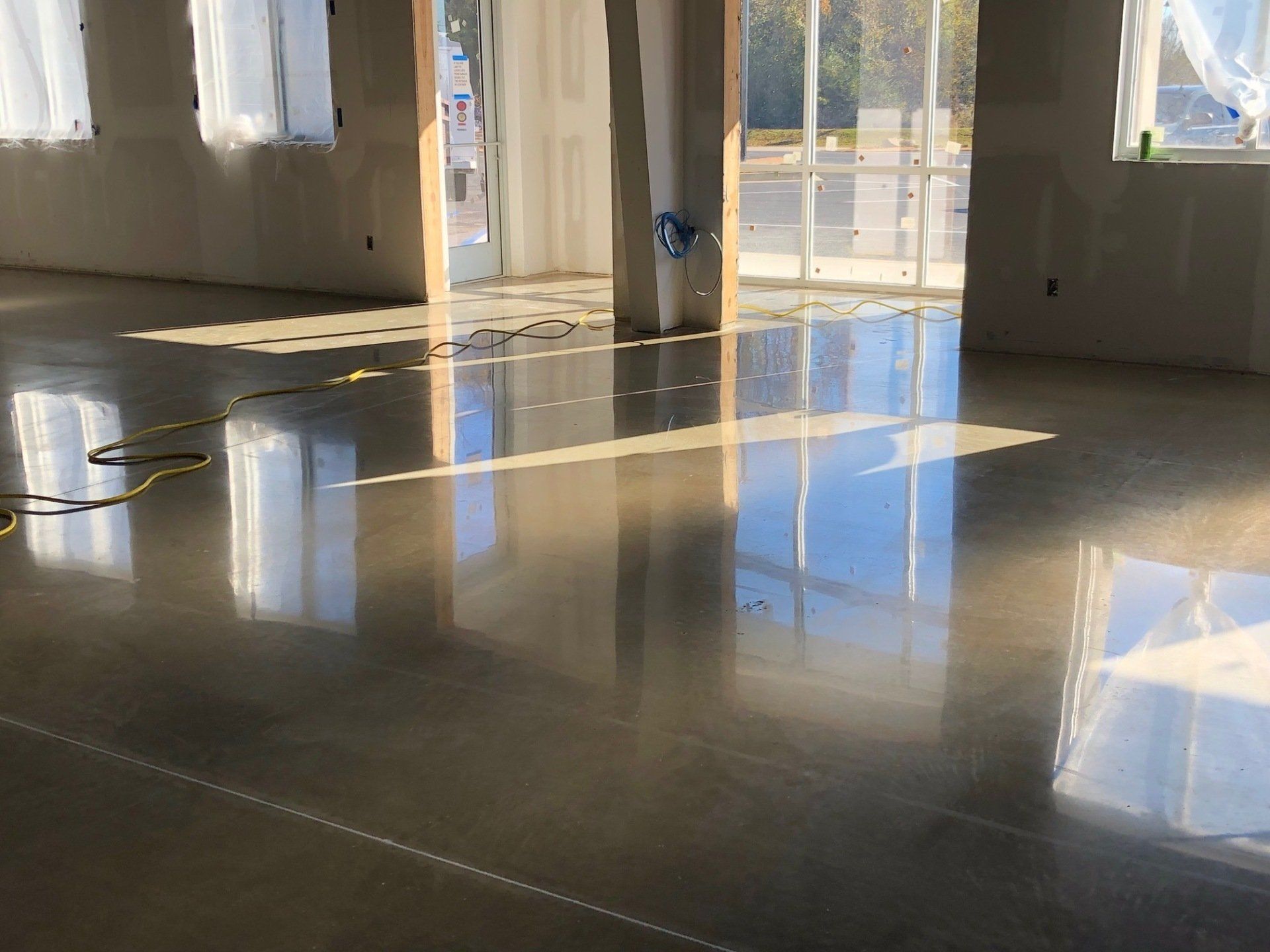 A large room with a shiny concrete floor and a lot of windows