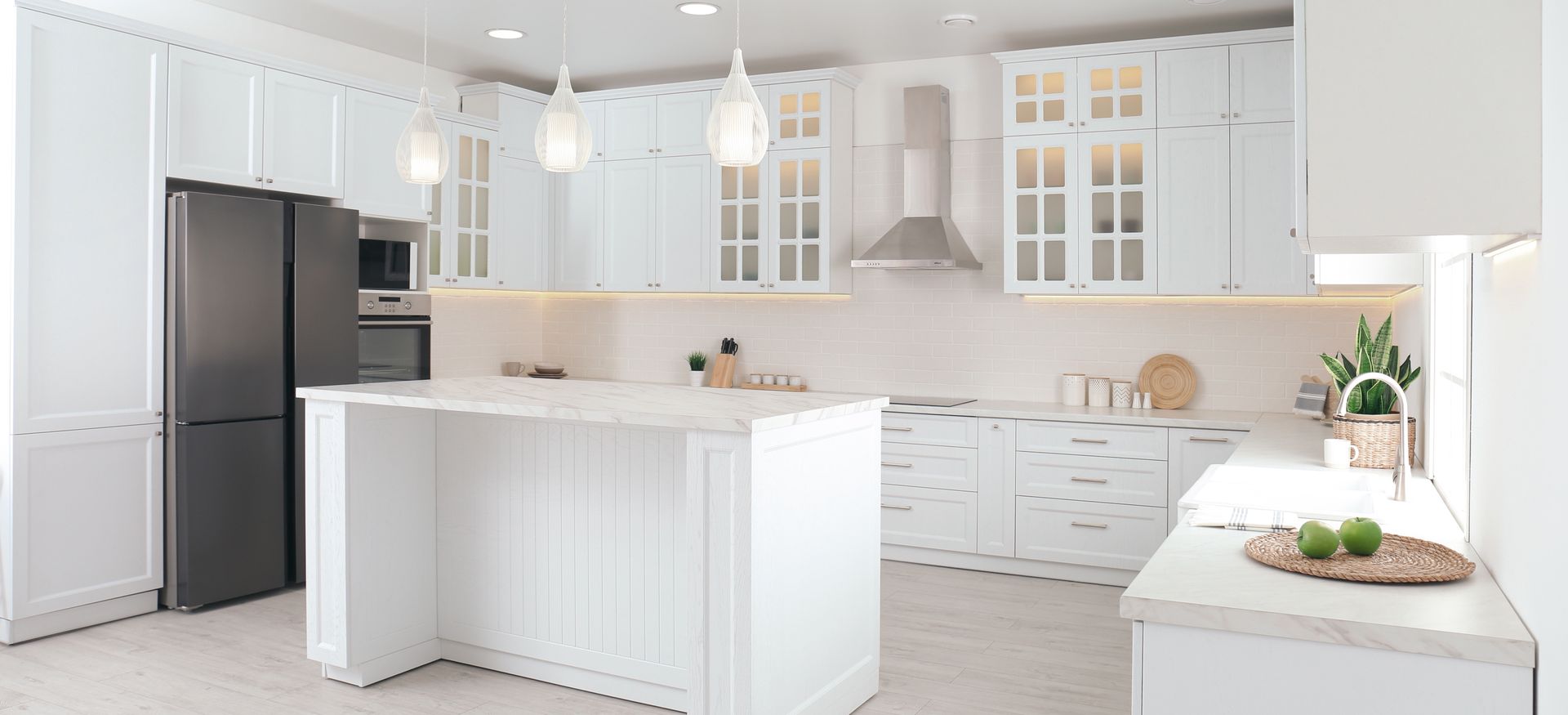 Bright white modern kitchen with island, black refrigerator, and glass-front cabinets