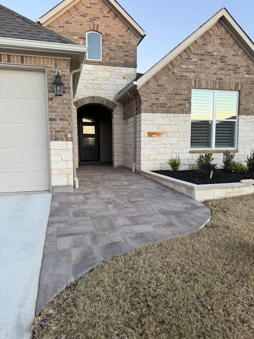 Front entrance with curved paver walkway and brick house exterior