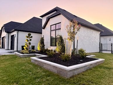 Suburban brick home with curved stone edging and green lawn landscaping