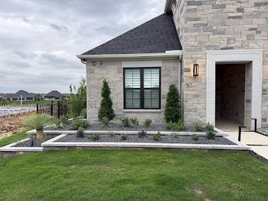 Modern stone house with professionally landscaped front yard in Denton TX