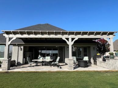 Patio with pergola and outdoor seating under clear blue sky in Denton TX