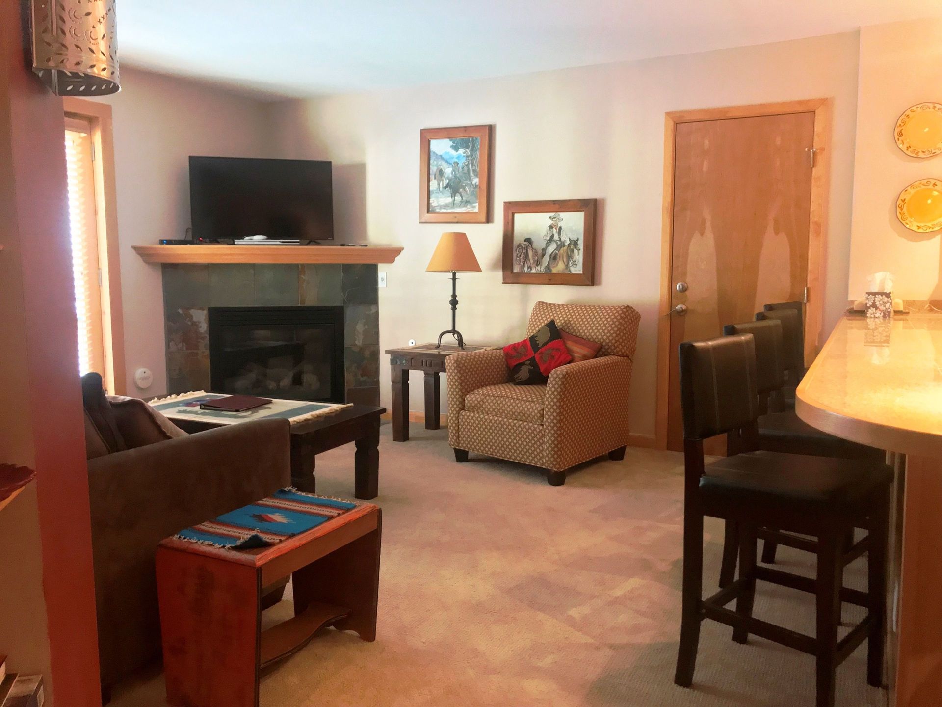 A living room with a fireplace and a flat screen tv