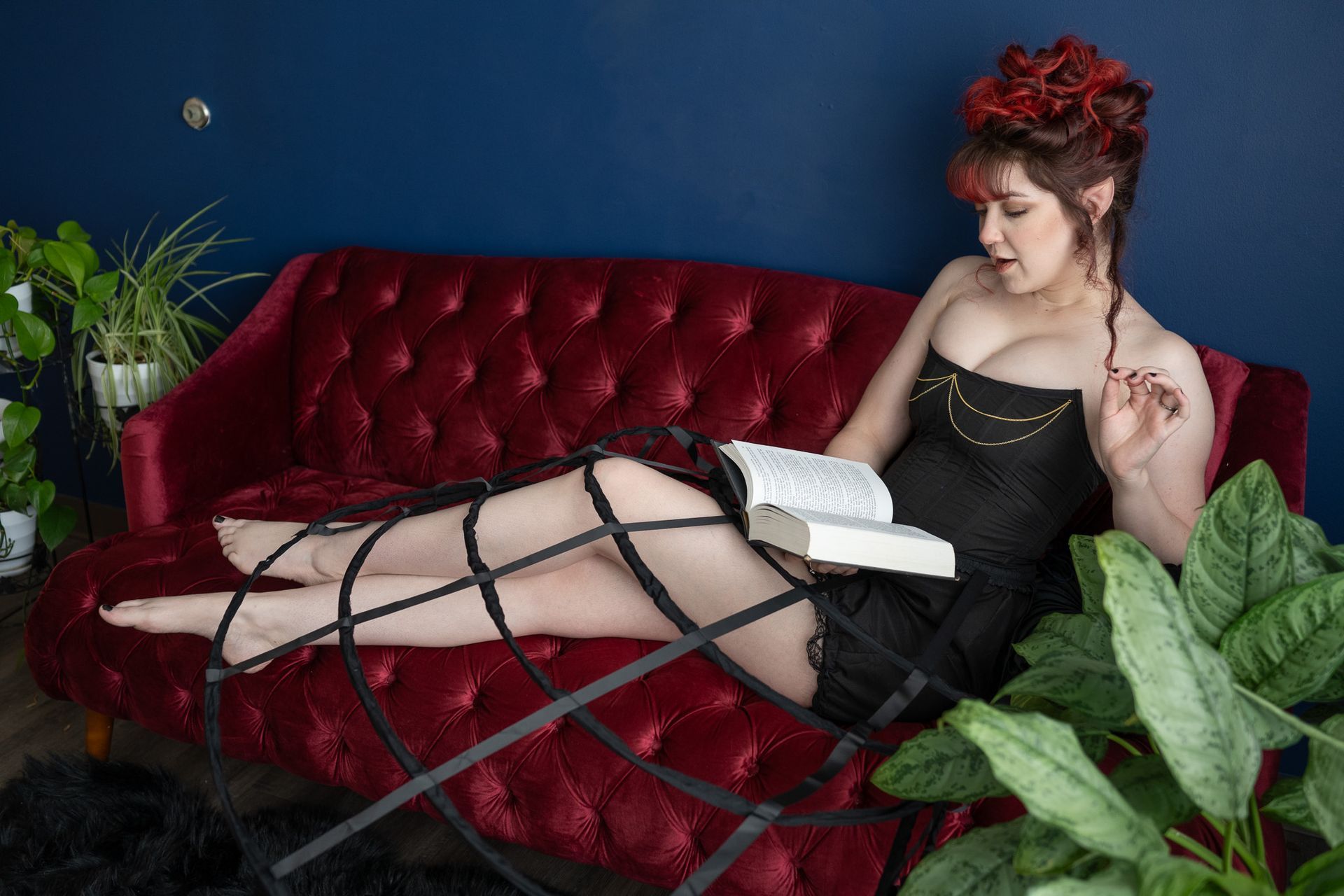 A woman is sitting on a couch reading a book.