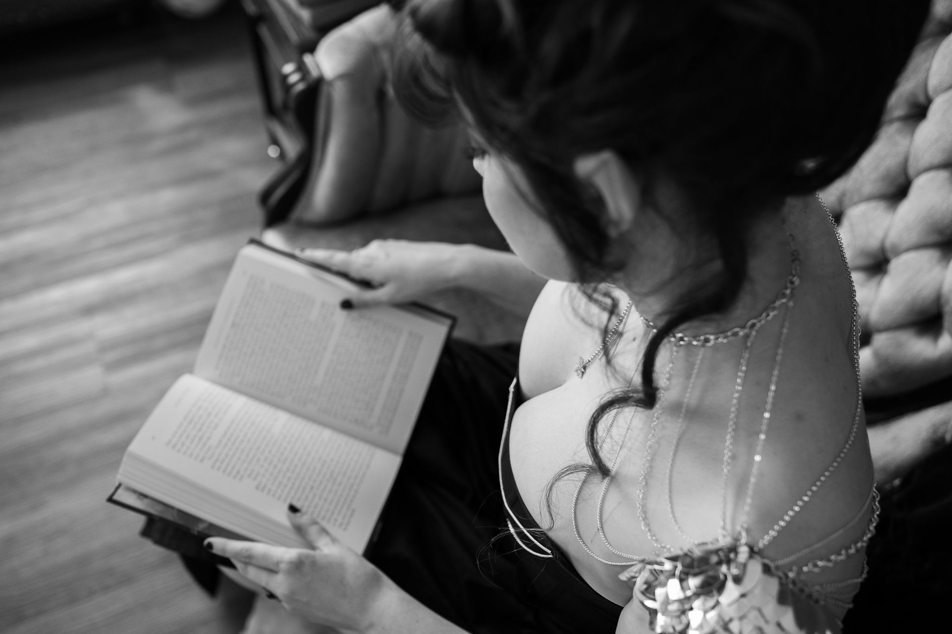 A woman is reading a book in a black and white photo.