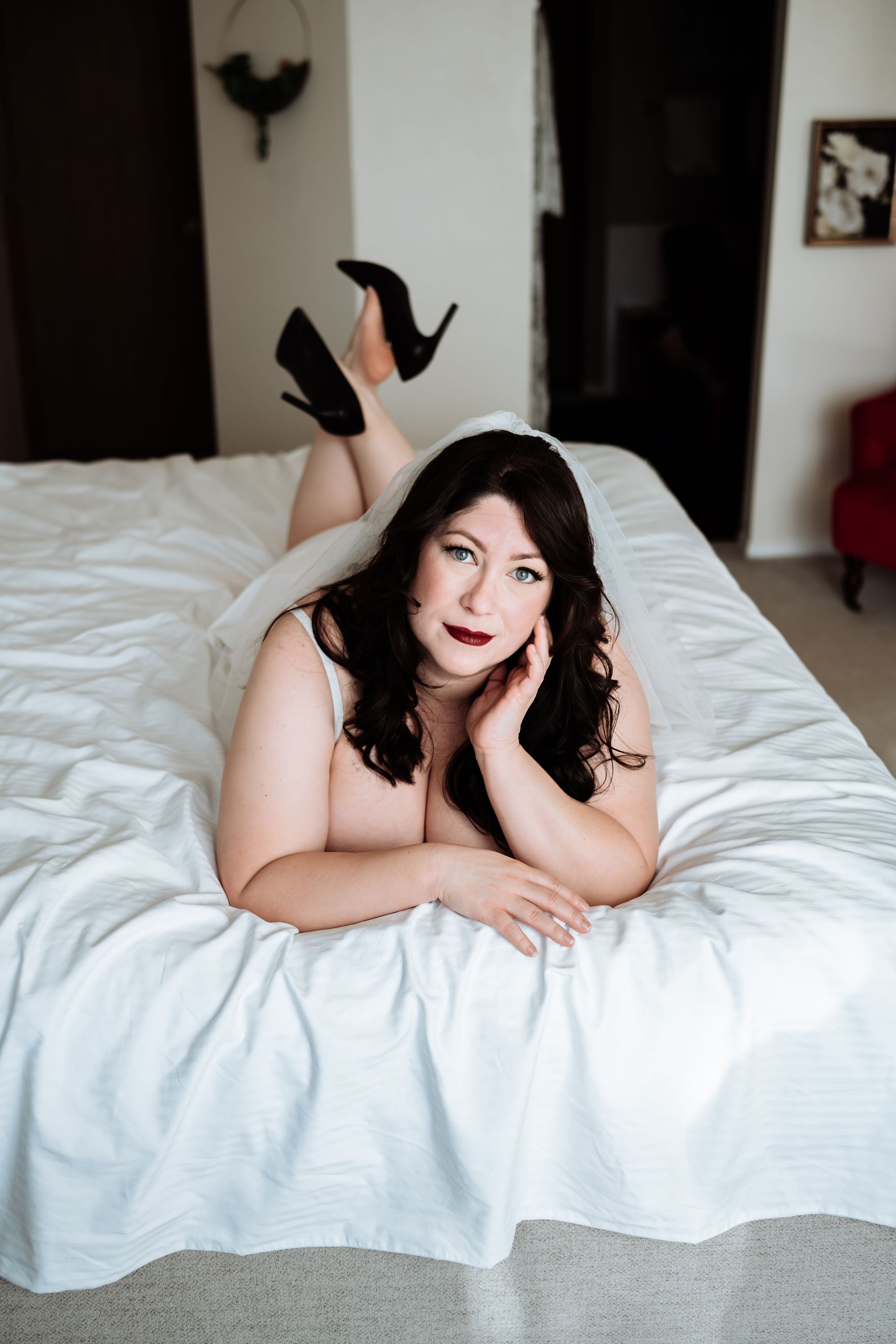 A woman is laying on her stomach on a bed.