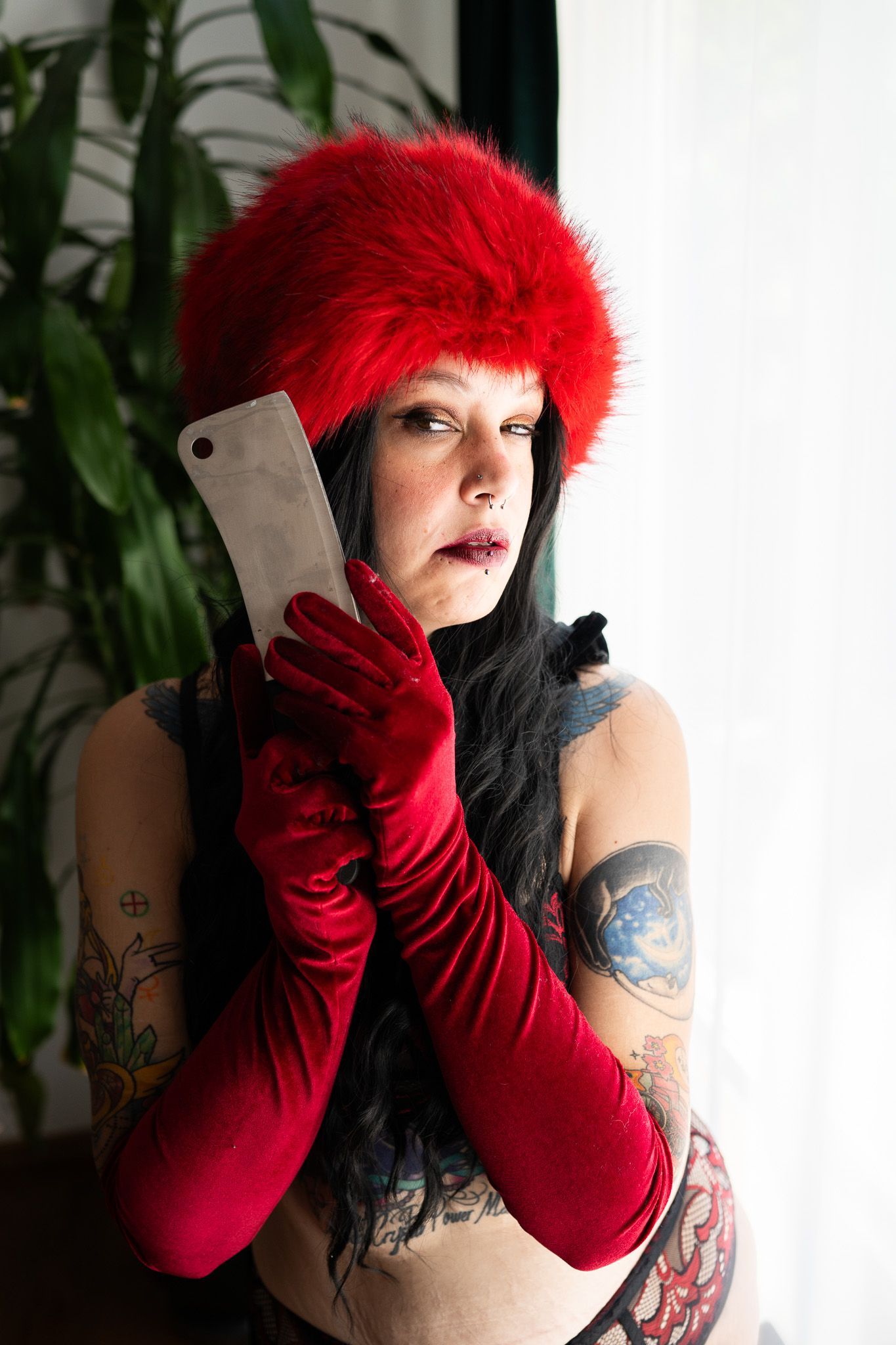 A woman wearing a red hat and red gloves is holding a piece of paper.