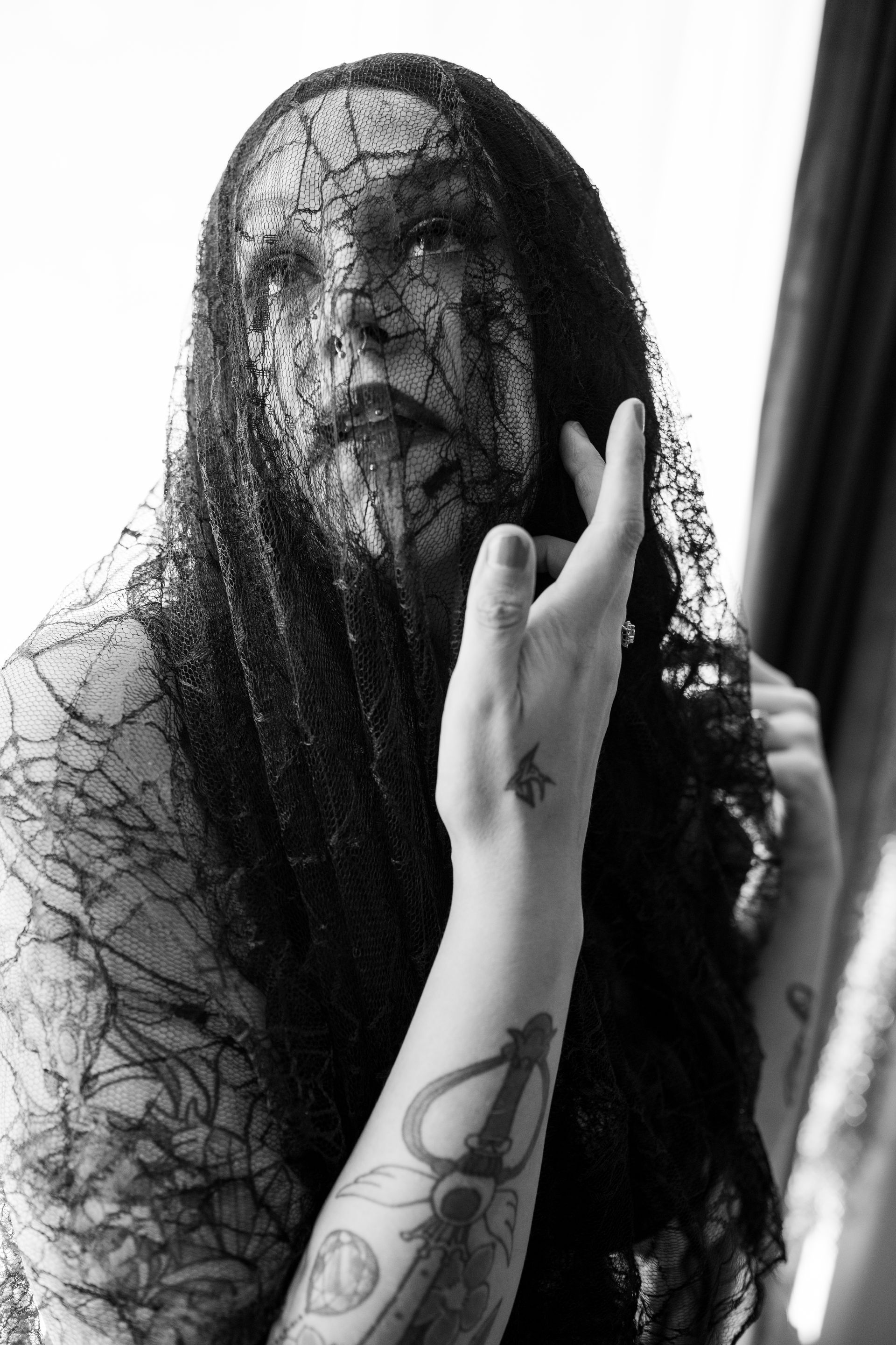 A black and white photo of a woman with a veil on her face