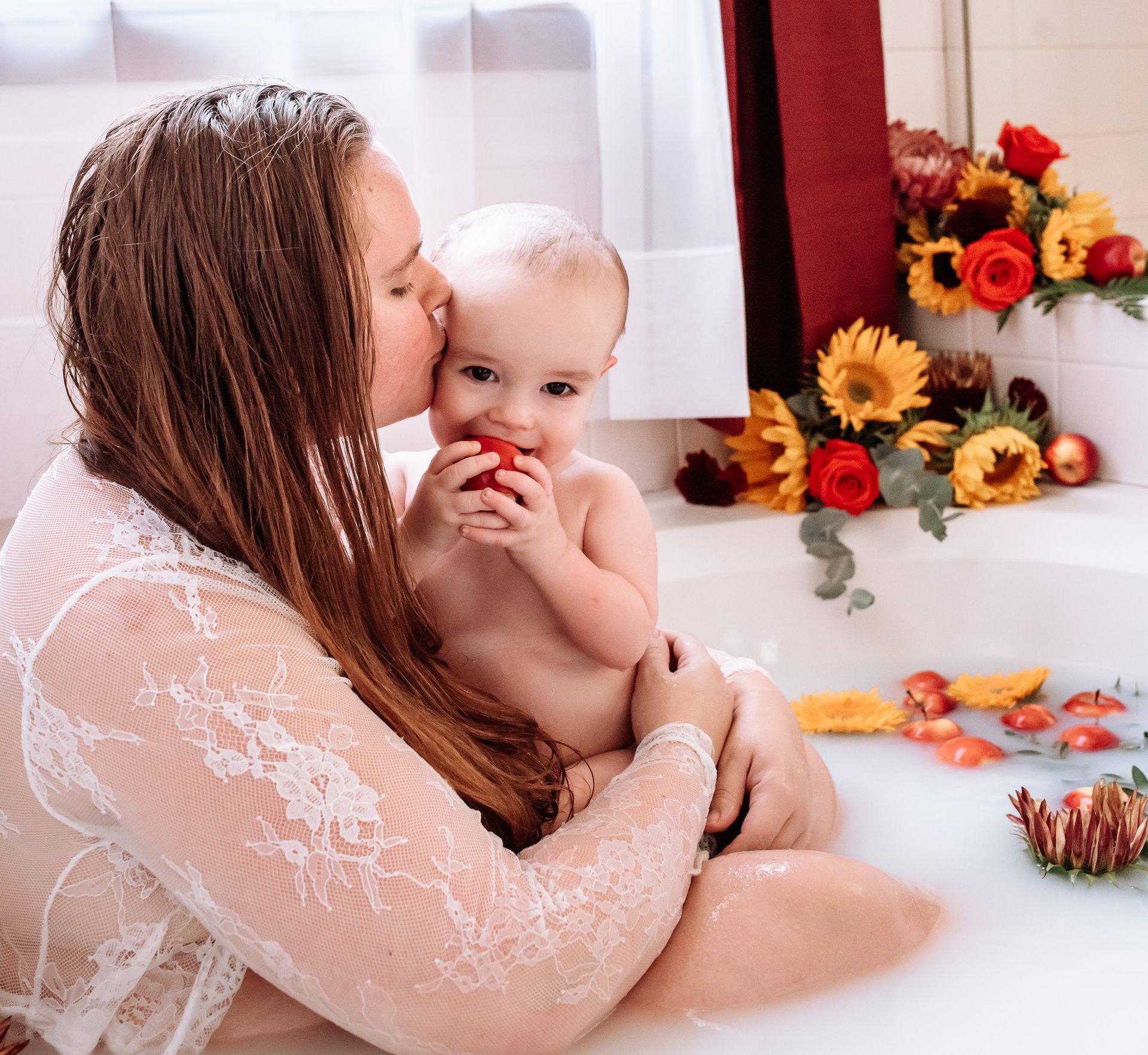 I woman in a bathtub with a baby. 