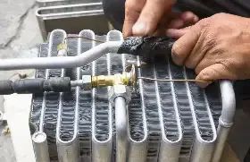 A Man Is Working On A Car Air Conditioner Coil With A Wrench — Autocool Air Conditioning in Raymond Terrace, NSW