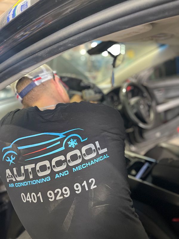 A Man Is Working On The Inside Of A Car — Autocool Air Conditioning in Raymond Terrace, NSW
